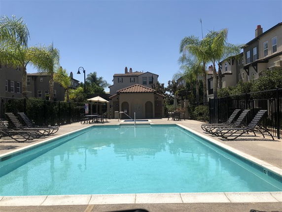Outdoor swimming pool area surrounded by residential buildings.