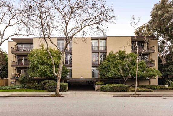 Front view of a multi-story apartment building with balconies.