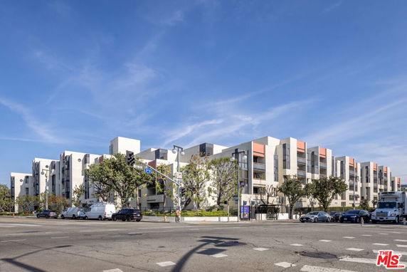 Front view of a modern multi-story apartment building with a clean façade and large windows.
