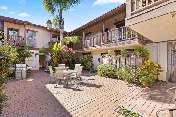 Outdoor patio area of a residential building with seating and plants.
