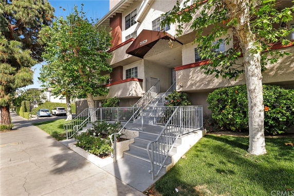 Front view of a multi-story residential building with staircase entry.