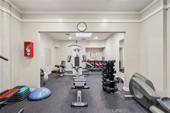 Interior view of a gym area with various exercise equipment including weights and cardio machines.