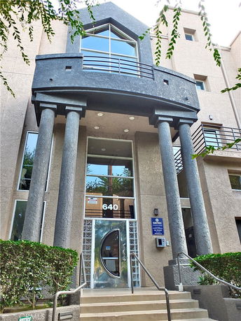 Front view of a multi-story building with prominent columns and large windows.