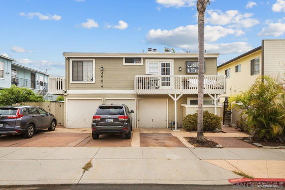 Front view of a two-story house with a balcony and double garage.