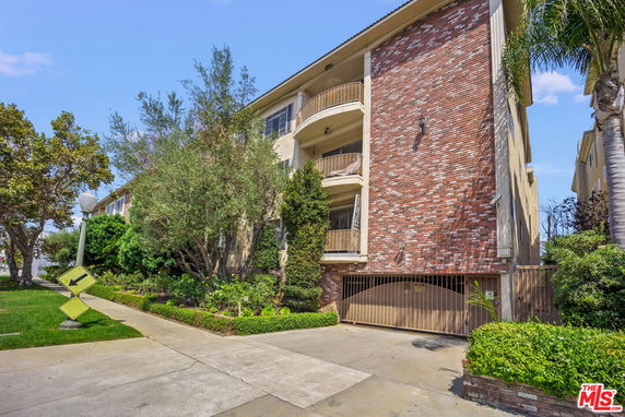 Front view of a multi-story residential building with balconies and a brick exterior.