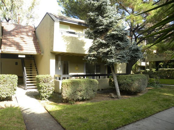 Front view of a two-story apartment building with external staircase.