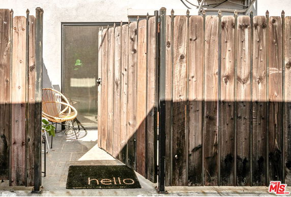 Entrance view of a house with a wooden fence and a glass door.