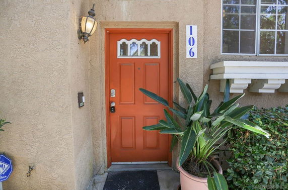Front view of a house entrance with an orange door.