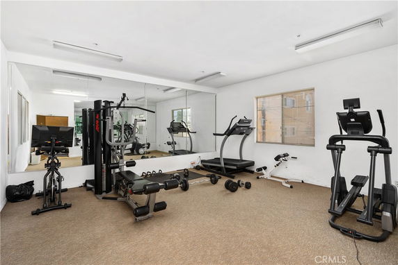 Indoor gym area with exercise equipment and mirrors.