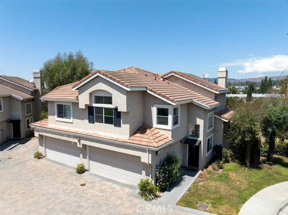 Front view of a two-story house with a triple garage and tile roof.
