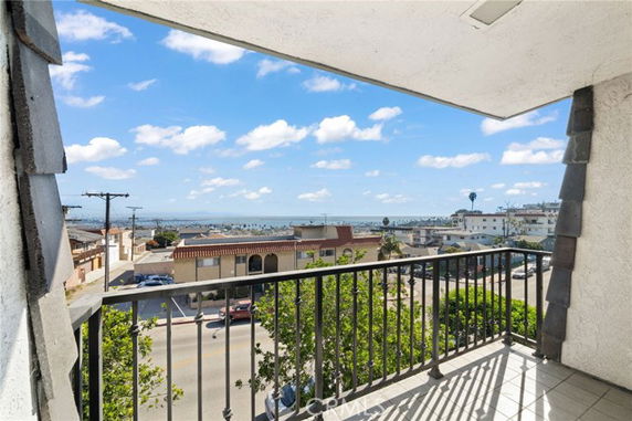 Balcony view overlooking a street and distant ocean.