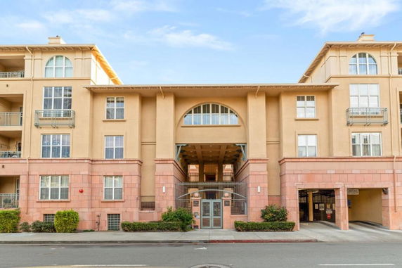 Front view of a multi-story building with multiple windows and balconies.