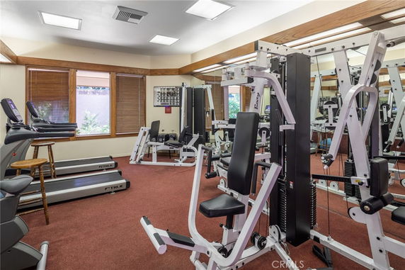 Indoor gym area with exercise machines and mirrors.