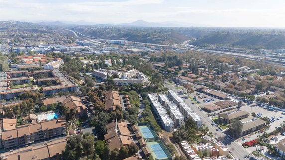 Wide-angle aerial view of residential and commercial buildings with surrounding landscape.