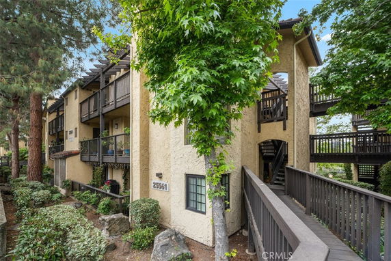 Front view of a multi-story building with balconies and wooden walkways.
