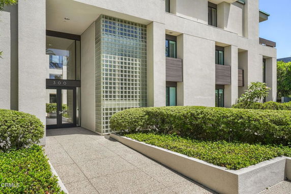 Front view of a modern multi-story building with glass block wall.
