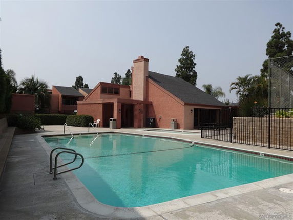 Outdoor swimming pool area adjacent to a red brick building.