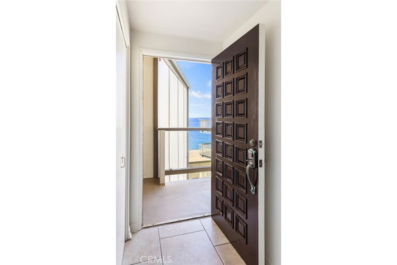 View from an open doorway showcasing the ocean horizon and a part of a building structure.