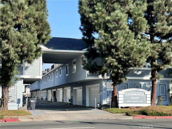 Front view of a two-story apartment building with garages on the ground level.