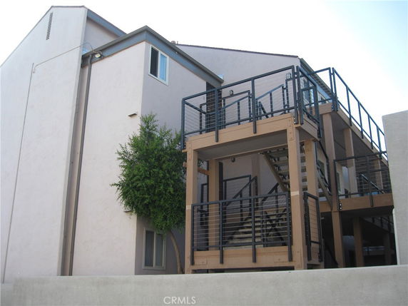 Front view of a multi-story building with external stairway and balconies.