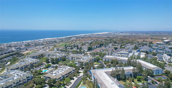 Panoramic view of a coastal area with residential buildings and a coastline.