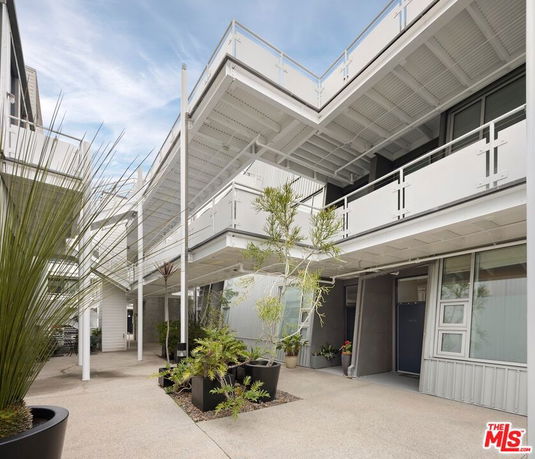 Modern building facade with balconies and potted plants
