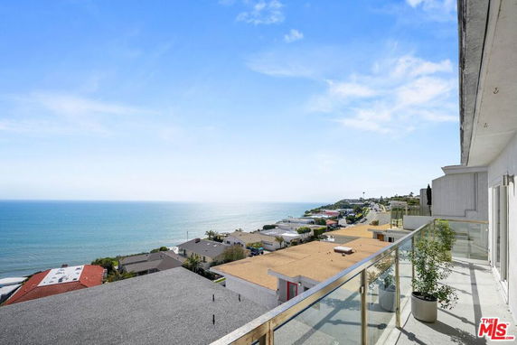 Wide angle view of the ocean and surrounding coastal area from a building balcony.