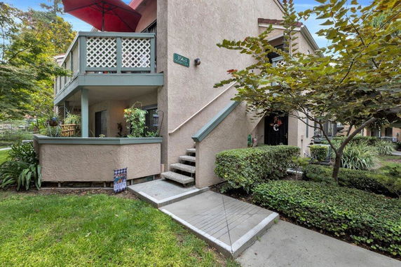 Front view of a two-story house with an upper balcony and staircase.