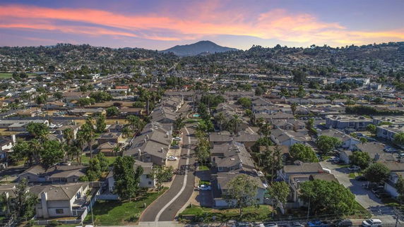 Aerial view of a suburban neighborhood with houses and a mountain in the distance.
