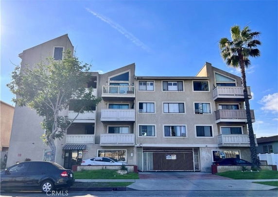 Front view of a multi-story apartment building with balconies.