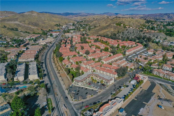 Aerial view of a residential area with multiple housing complexes surrounded by hills.