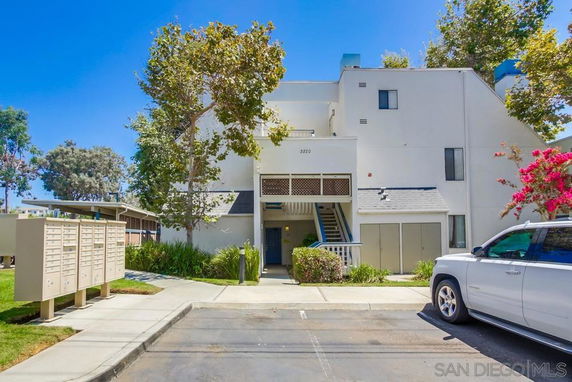 Front view of a multi-story building with an entrance and exterior staircase.