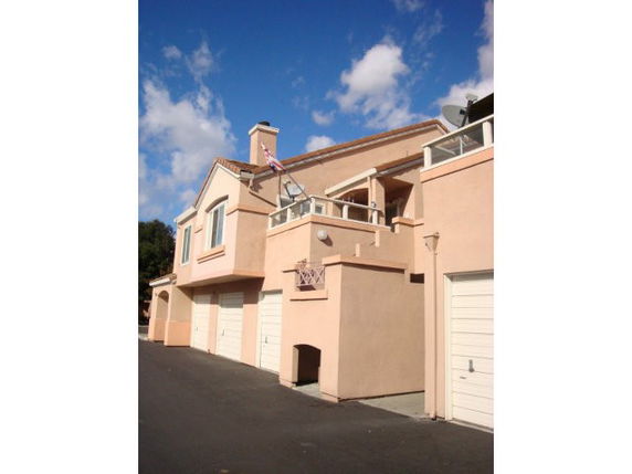 Front view of a house with multiple garages and a balcony.