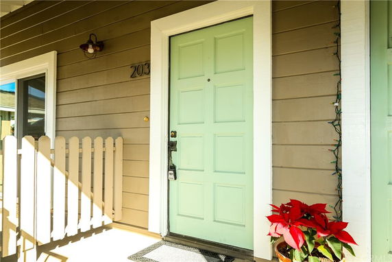 Front view of a house with a light green door and beige siding.