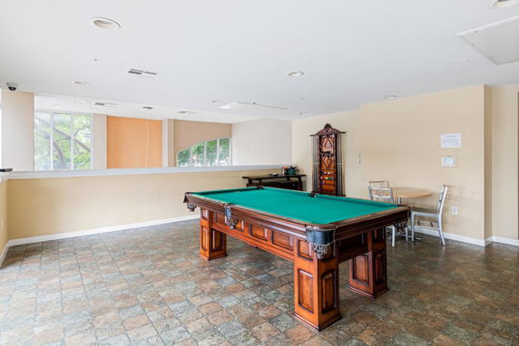 Room with a billiards table and seating area.