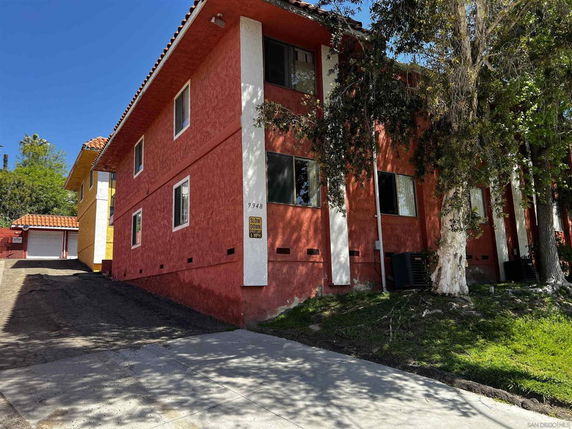 Front view of a two-story house with a red exterior and multiple windows.