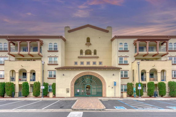 Front view of a multi-story building with arches and balconies.