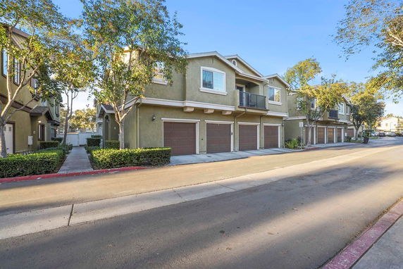 Front view of a multi-story townhouse with garages on the ground level.