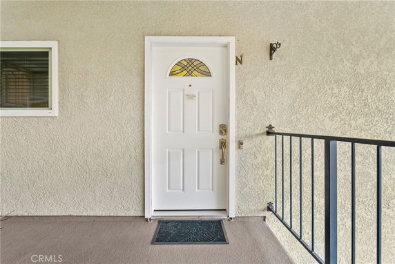 Front view of a door with a small window and railing