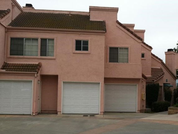 Front view of a two-story residential building with garage doors.