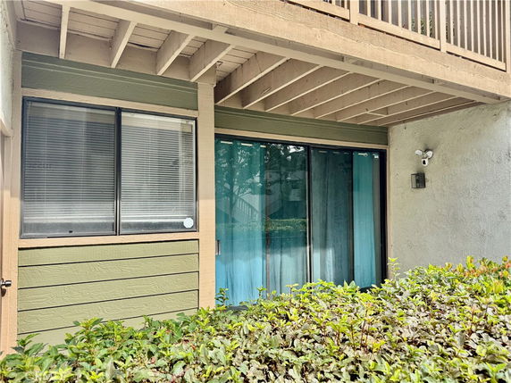 Exterior view of a building with sliding glass doors and a window next to it.