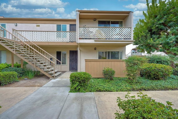Front view of a two-story building with external staircase and balcony.