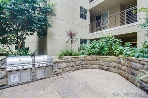 Outdoor patio area with built-in grills and surrounding greenery.