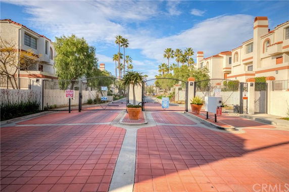 Front view of a gated community with multi-story residential buildings.