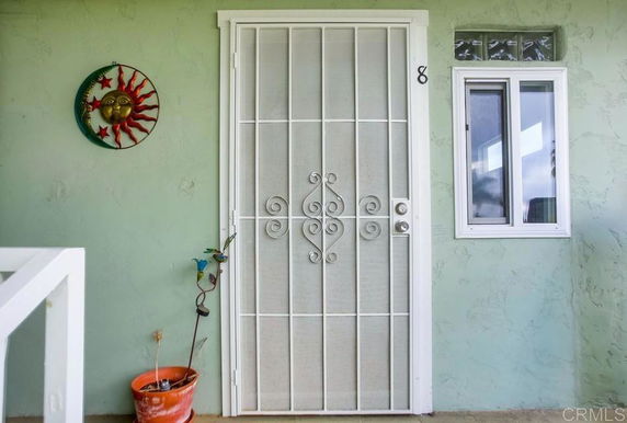 Exterior view of a house entrance with a decorative door and small window.
