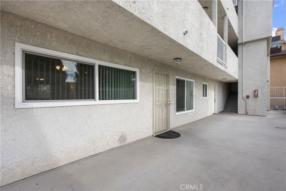 Exterior view of a building with a concrete surface suitable for parking and entry door with windows.