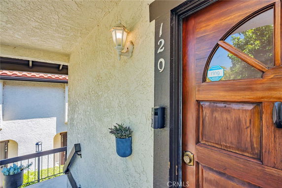 Front view of a building entrance with a wooden door and wall lantern.