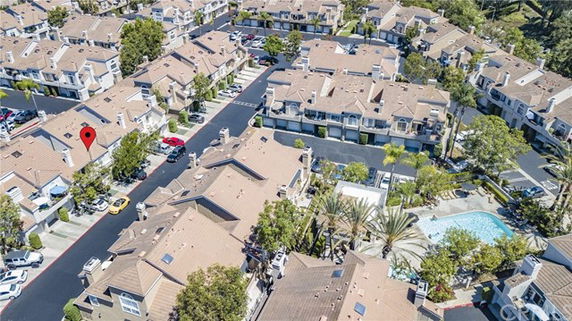 Aerial view of residential complex with multiple houses and a swimming pool.