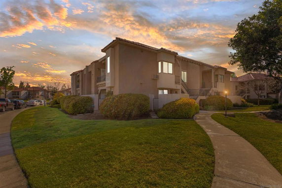 Front view of a two-story residential building with landscaped pathway.
