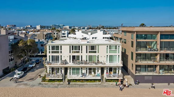 Front view of a multi-story beachfront building with balconies.
